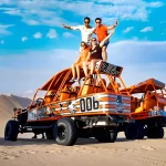Image of the oasis surrounded by giant dunes and buggies in full action.
