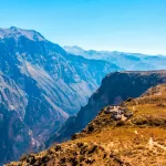 Panoramic view of the Colca Canyon showing its enormous walls, agricultural terraces and the river in the background.