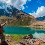 Wide shot of the lagoon with its characteristic turquoise color and the Humantay snow-capped mountain behind it.